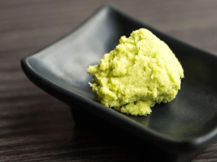 serving freshly grated wasabi in a little black bowl on a dark wooden table