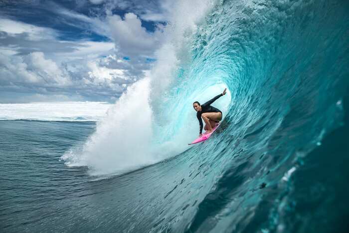 surfer in a large blue wave catching the wave summer sports