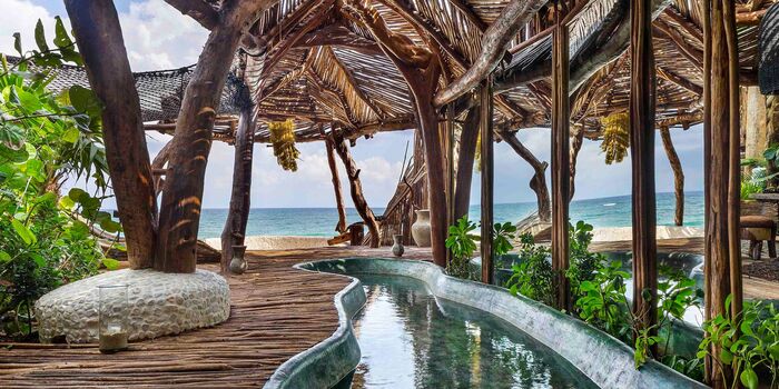 Resort in Tulum Mexico with a water canal and wooden structure around