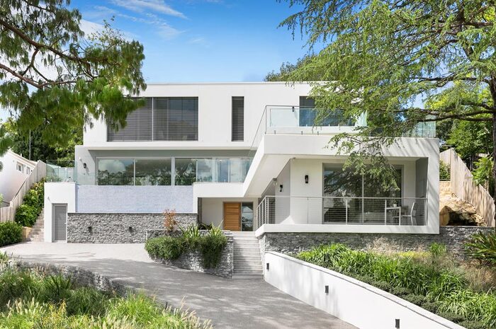 white modern villa with small yard surrounding the property