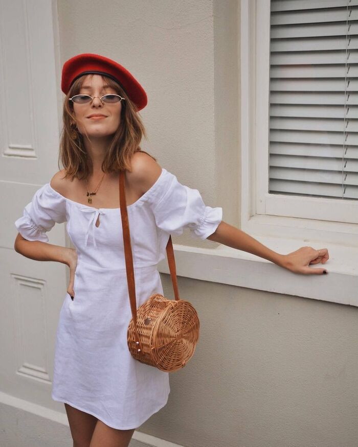 beret summer hat woman dressed in white with a red beret and glasses smiling at the camera