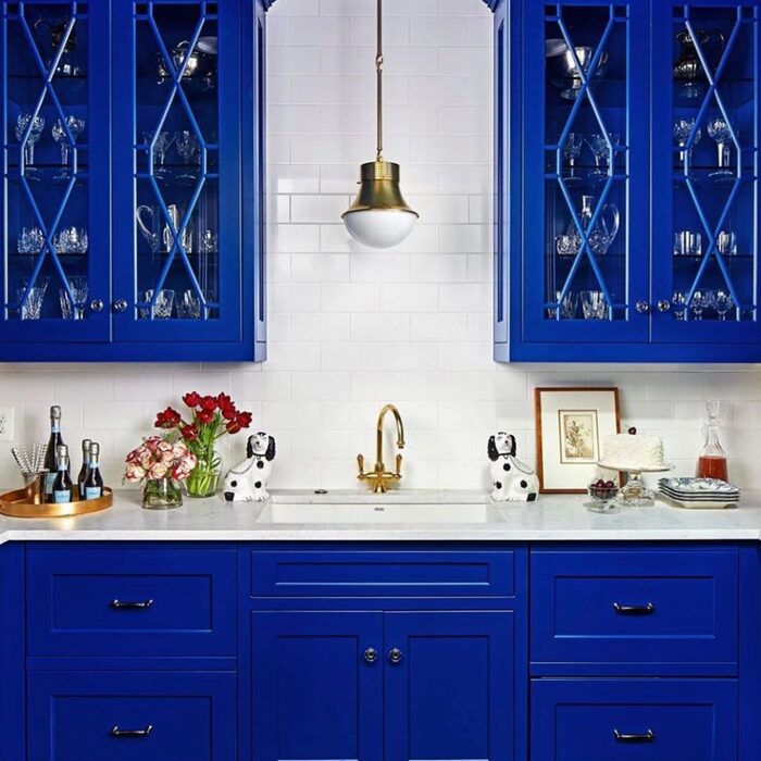 blue kitchen with a white back wall and metal details