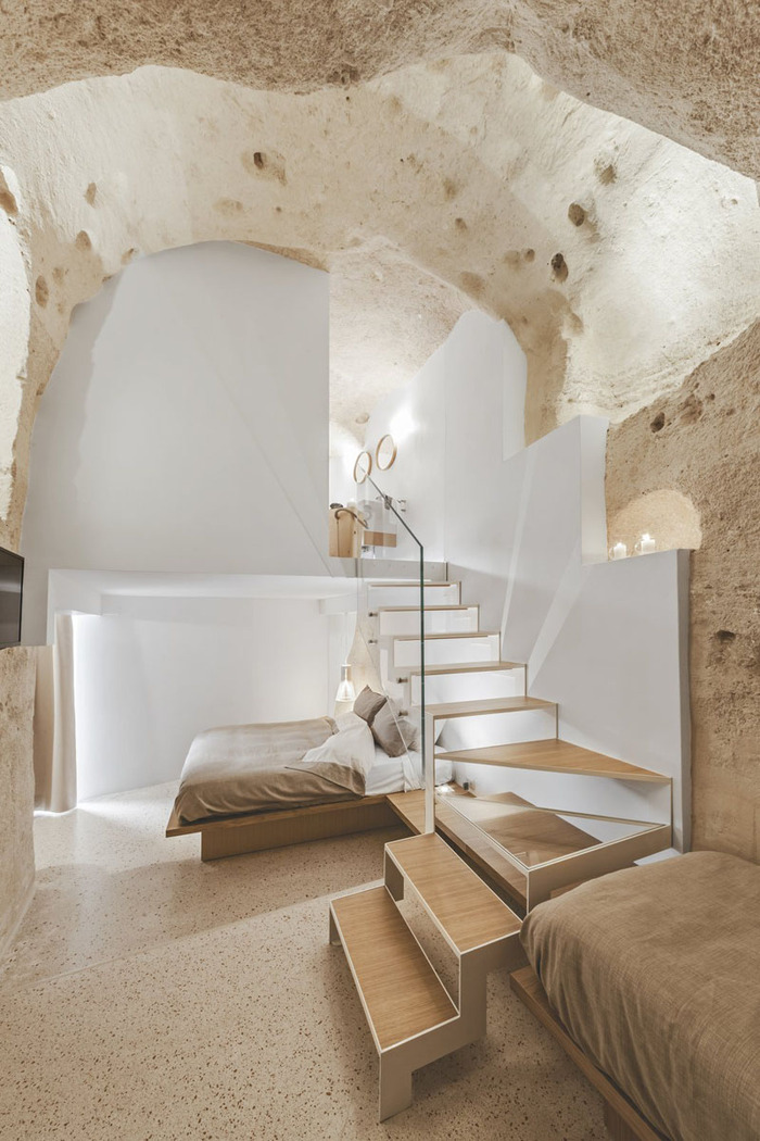 boutique hotel cave interior design with stairs white walls and stones 