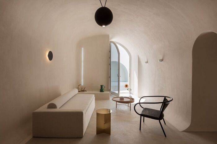 cave house santorini with white sofa and black chair large window open to the outside