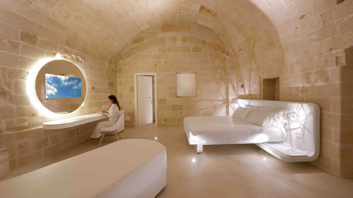 cave room in a hotel white furniture and woman in white gown sitting in front of a mirror