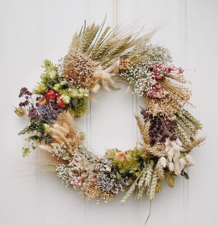 dried flowr wreath hanging on a white door different dried flowers arranged in a pretty wreath