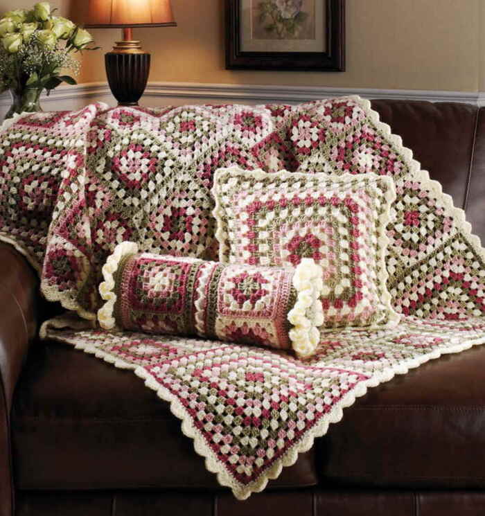 granny squares throw and pillows in colorful pattern on a brown leather sofa