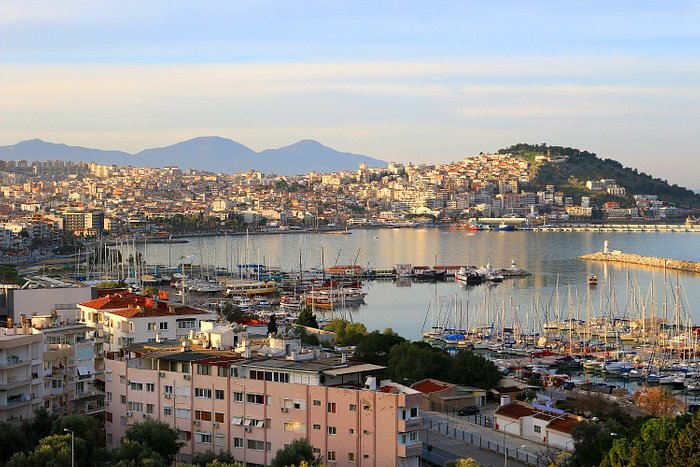 kusadasi tourist photo over the city with a hill on the other side and many boats in the harbour