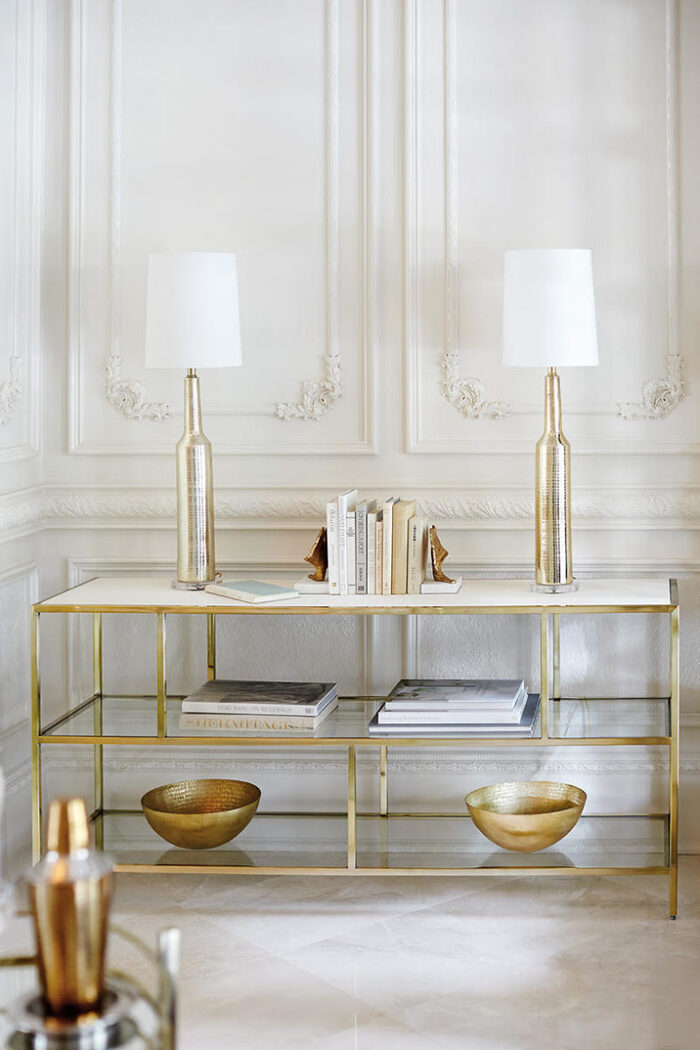 elegant metal decor details on a piece of furniture in a white room with white lamps