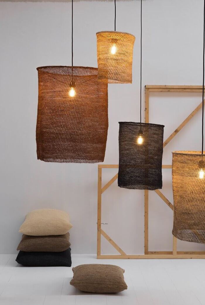 natural lamps in different shades of brown hanging from the ceiling with pillows on the floor