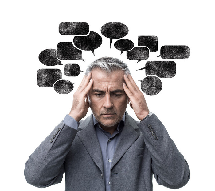 negative thoughts man in a suit holding his head full of negative thoughts around his head