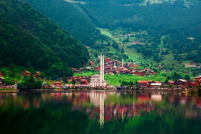 visiting Turkey trabzon a large mosque on a lake surrounded by green forests and houses