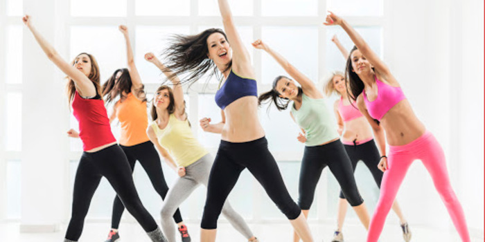 women in colorful sports outfits dancing and working out