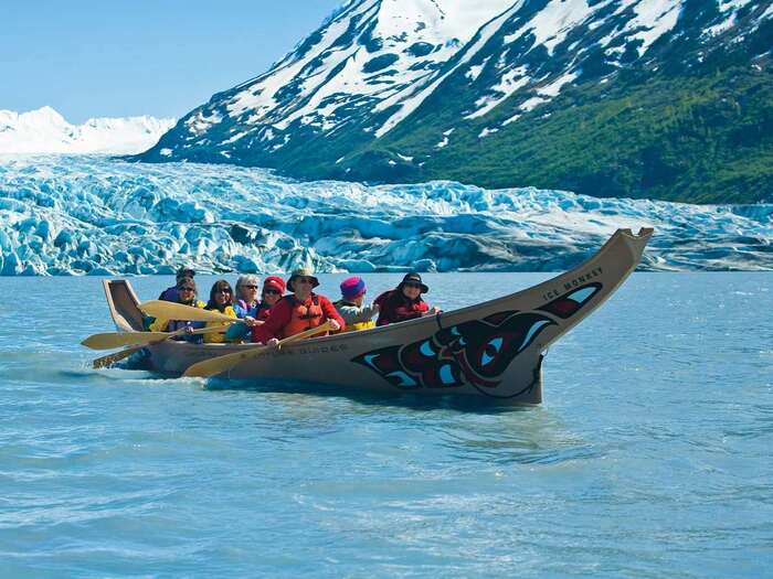 alaska eco tours people in a boat rowing with glaciers in the background