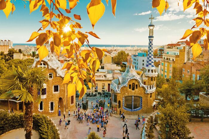 barcelona gaudi park tourist sight and yellow leaves on branches in the forefront