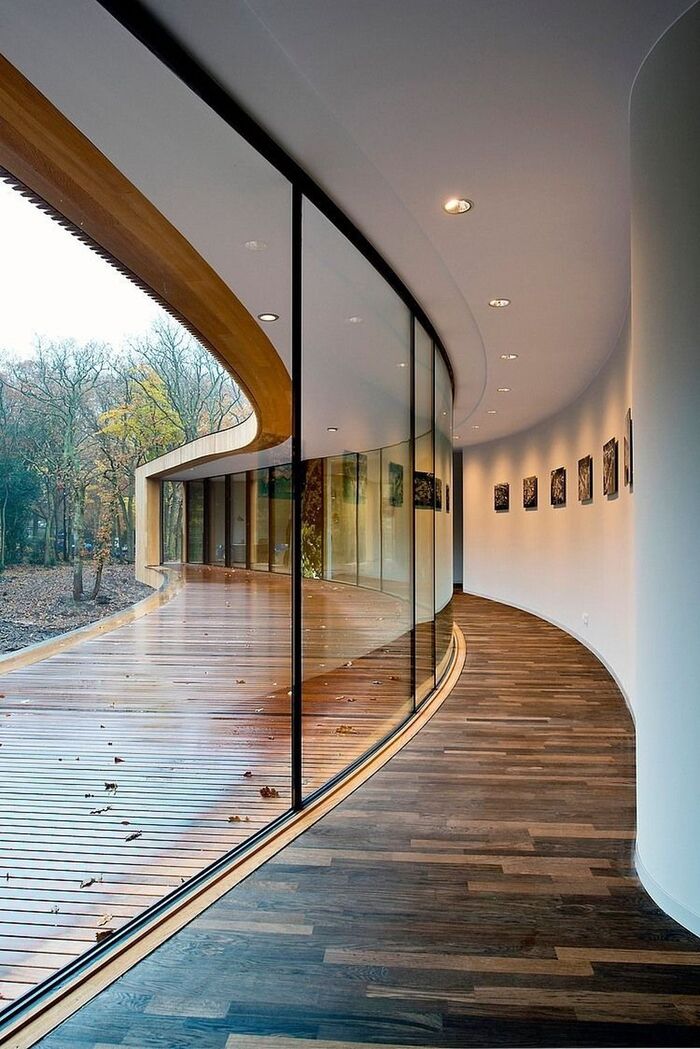 modern corridor with dark wooden floor and large windows white curves