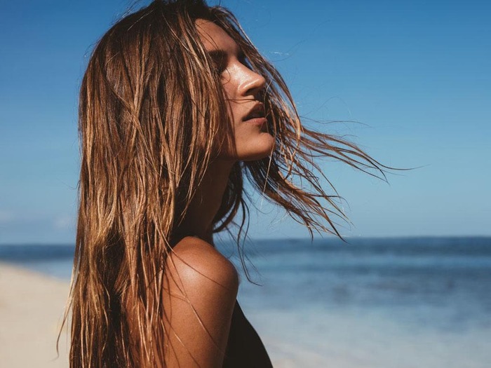 woman on the beach with her hair down enjoying the sun 