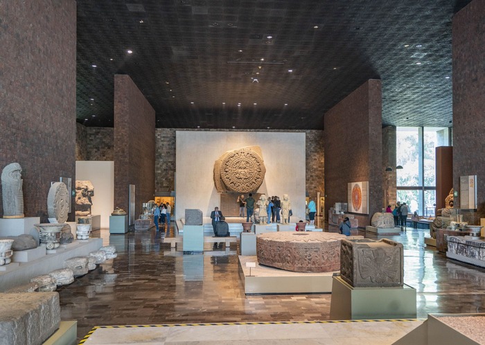 mexico museum exhibition artefacts arranged in stone room people looking around