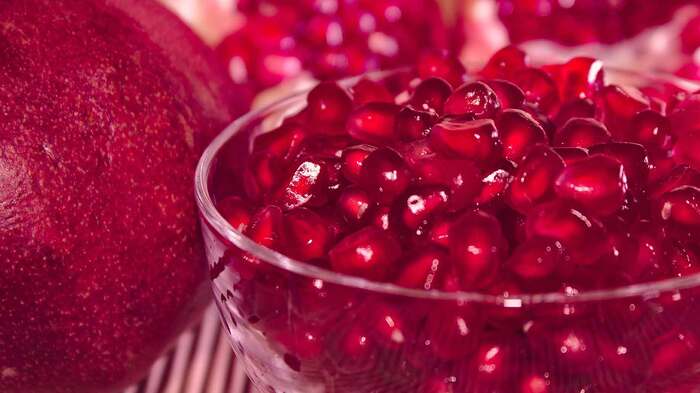 pomegranate fruit with a glass bowl full of pomegranate close up red fruit