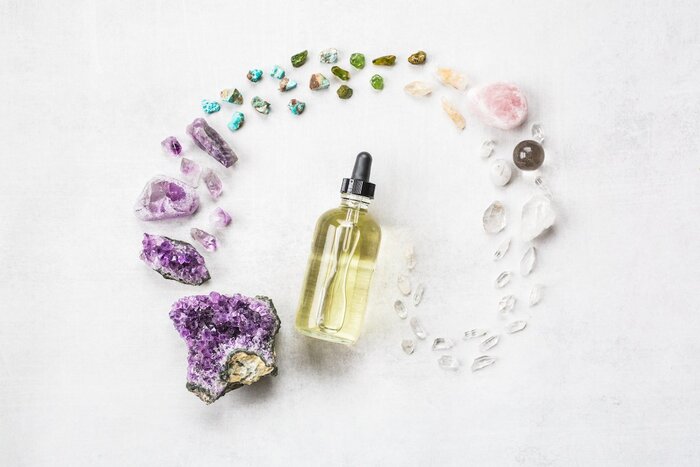 serum secrets large bottle with a light yellow serum surrounded by stones and crystals