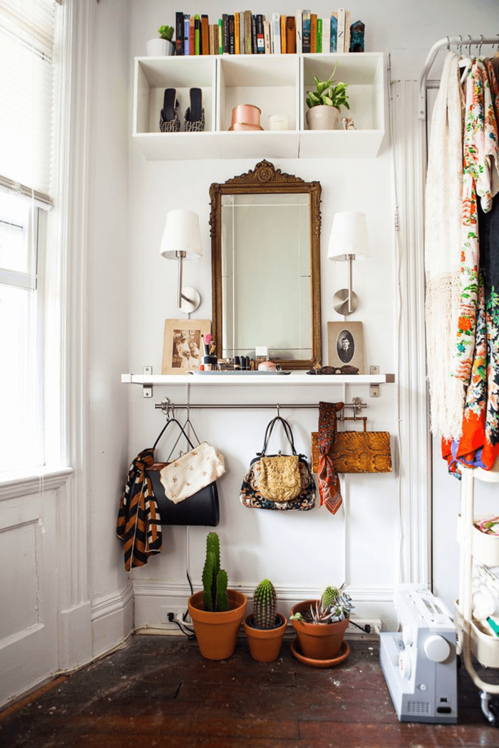 small white entryway furnished in boho style with a mirror and living cacti 