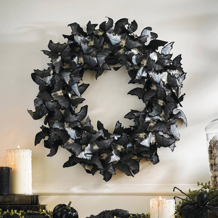 large black halloween wreath made of black paper baths flying in a circle