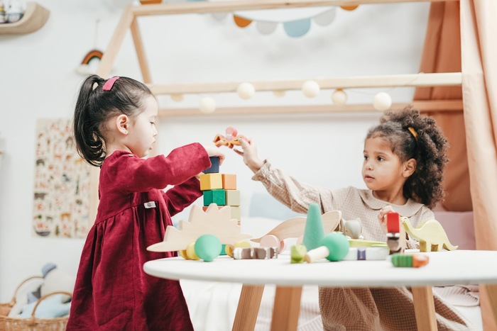 little children playing around a white table at home one 