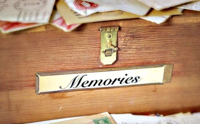 wooden memories box with a label and golden lock and many envelopes on top
