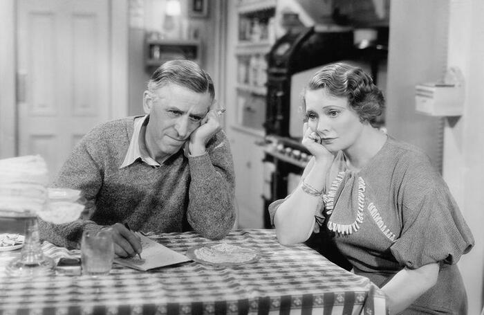 the chewing diet a man and woman in a black and white photography sitting in the kitchen on the table supporting their faces with their hands