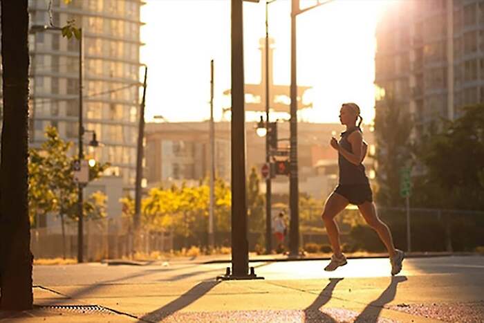 woman in sportswear running outdoors in the morning in the city