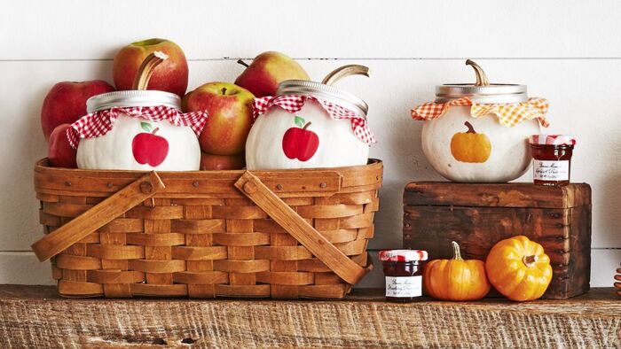 fall crafts basket filled with apples and jars with jam decorated with little pumpkins