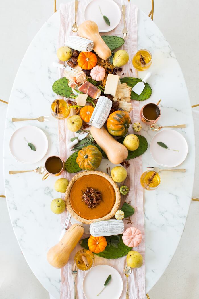 magical table marble table with white plates golden utencils pumpkins in different sizes and colors