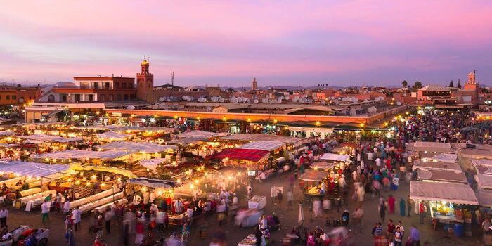 marrakech Jemaa el-Fna open air food market in the evening with many lights and people