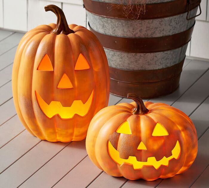 two large carved pumpkin lanterns on a porch floor