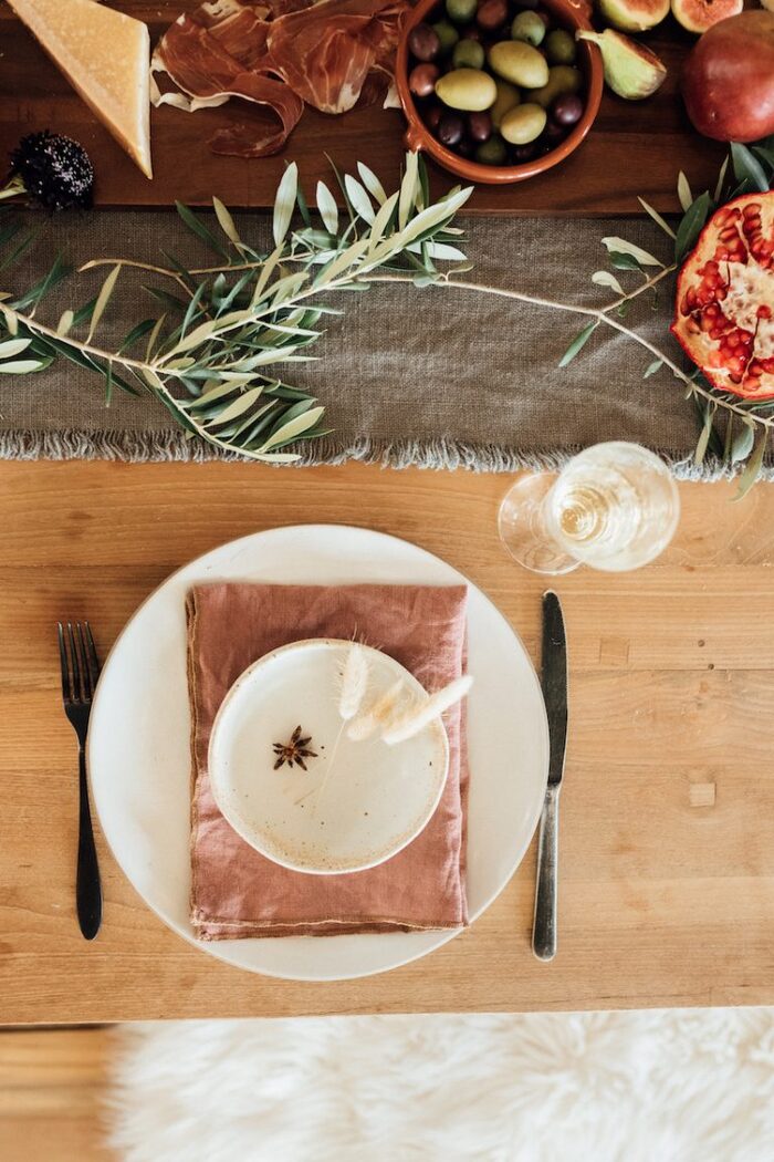 simple table design with olive branches pomegranates on a light wooden table