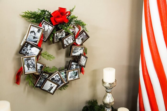 memory fall wreath made of framed photos and decorated with red ribbon and green branches