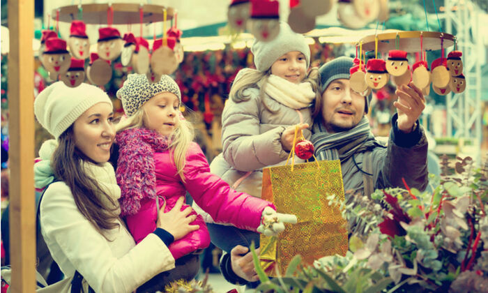 buying gifts family of four buying gifts at a christmas market picking and looking at decorations