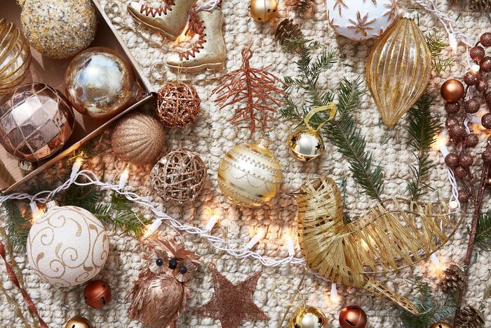 christmas decorations from above different golden baubles on a white carpet