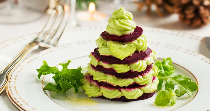 healthy food veggie christmas tree with green cream and slices of beetroot on a white festive plate