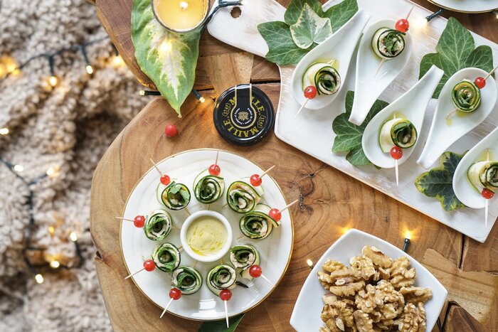 holiday food healthy holiday snacks on a wooden table with courgette rolls and cherry tomatoes