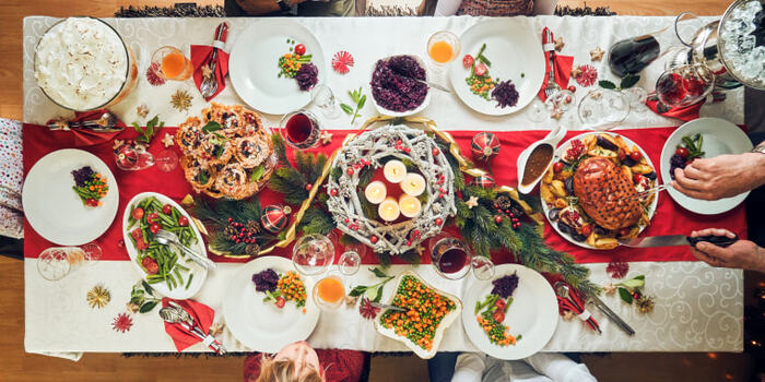 holiday table from above with various decorations and meals and people sitting around it