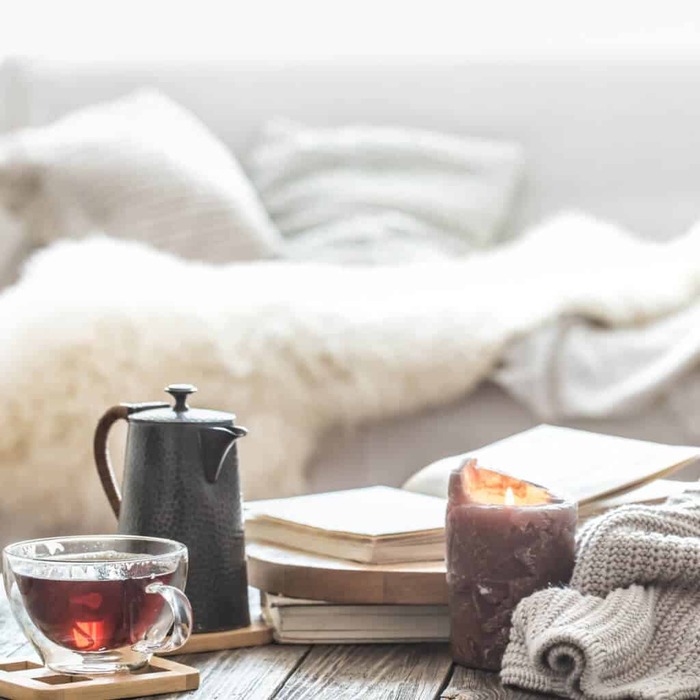 winter morning routine candle tea pot and tea cup and a couch in the background