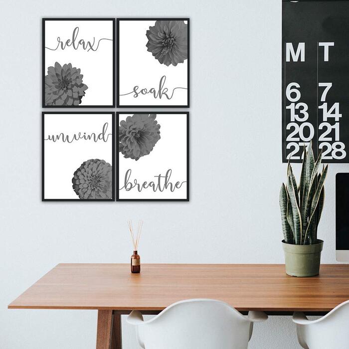 floral wall with black and white prints wooden table with a living plant 