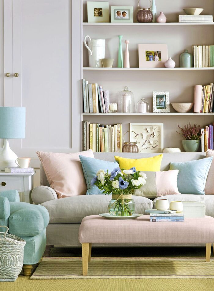 pastel living room space with a pink table and pastel decorative cushions library in the background