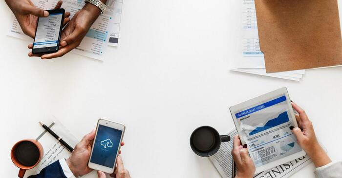 smart decisions people's hands on a white office table surface holding mobile phones and reports