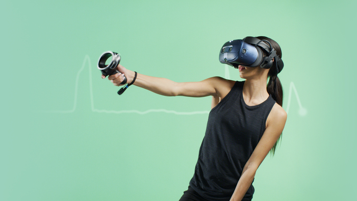 Woman on a green background with a black top trying a virtual reality set