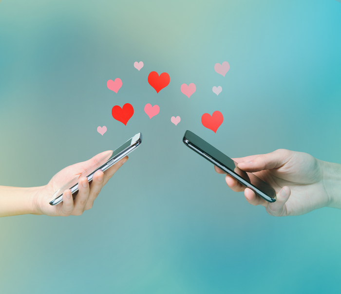 Smart phone love connection two hands holding smart phones sending love messages