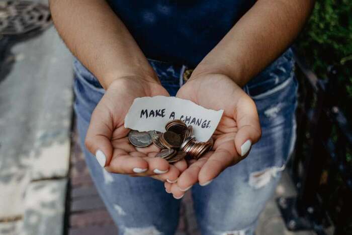 make a change woman dressed in jeans holding coins for honorable cause 