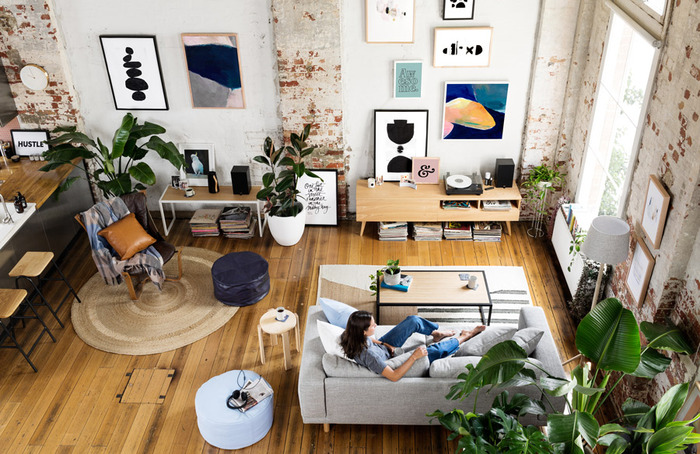 open floor plan apartment with huge art on the walls and woman sitting on a couch