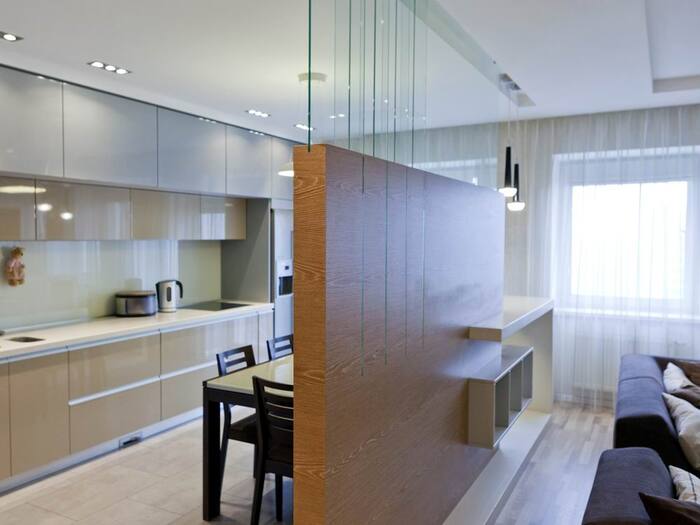 Partitions in the interior zoning and dividing a room into a kitchen and living space by a wall with glass on top